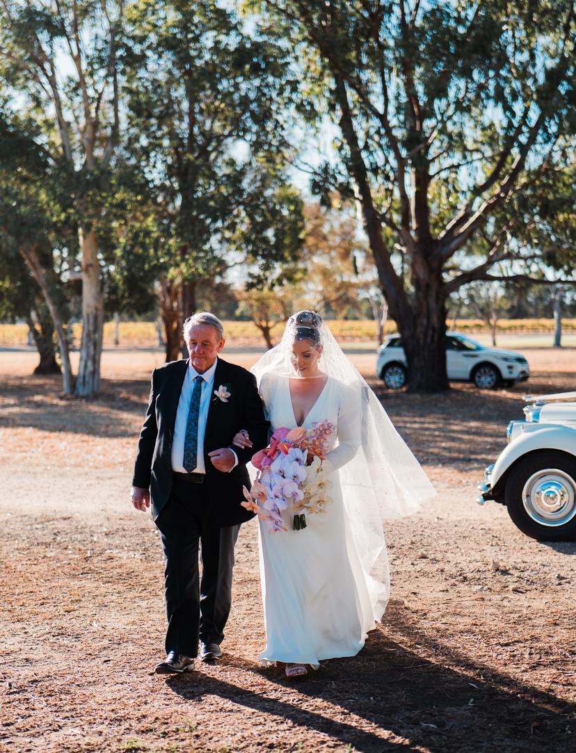 Bride Natalie walking down the aisle with her father by her side